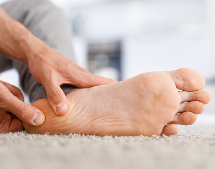 Man hands giving foot massage to yourself after a long walk